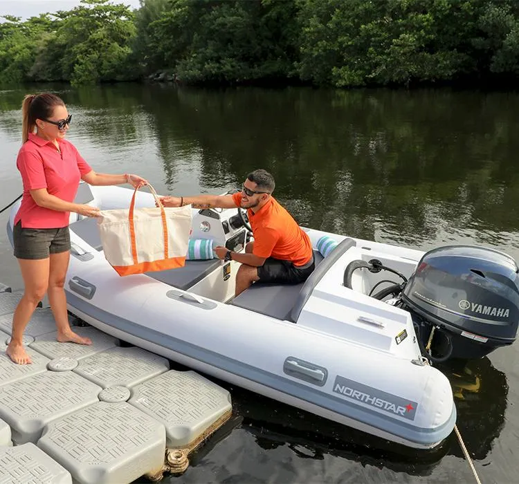Slide: The Image of 2023 Northstar Axis 3.8 boat at dock, people exchanging a bag, Yamaha motor visible. - 7