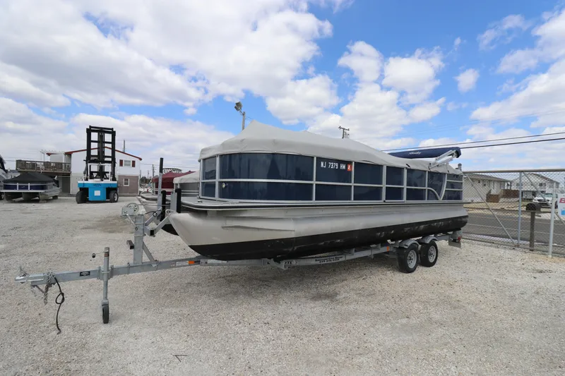Slide: The Image of 2019 Bentley Pontoons 240/243 Cruise on trailer, parked outdoors under a cloudy sky. - 1