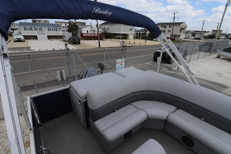 Slide: The Image of 2019 Bentley Pontoons 240/243 Cruise with gray seating, parked near a fence and road. - 10