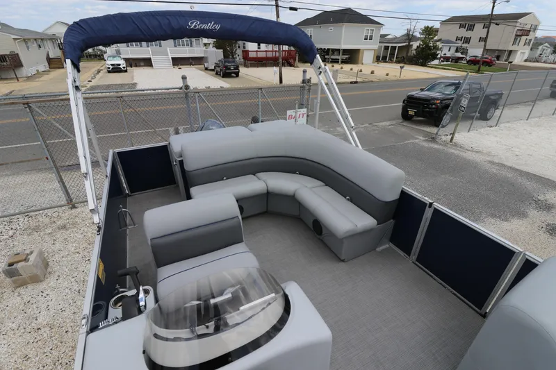 Slide: The Image of 2019 Bentley Pontoons 240/243 Cruise with spacious seating and canopy, parked near residential area. - 7