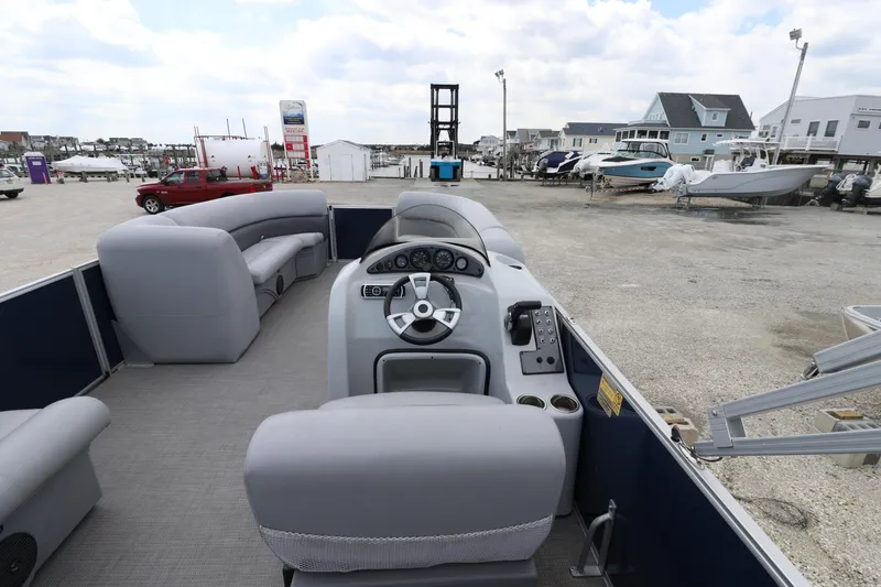 Slide: The Image of 2019 Bentley Pontoons 240/243 Cruise interior with gray seating and control panel, docked outdoors. - 8