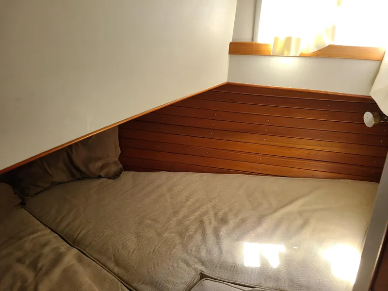Slide: The Image of Cozy cabin bed in 1989 Grand Banks 42 Classic yacht with wooden paneling and natural light. - 11