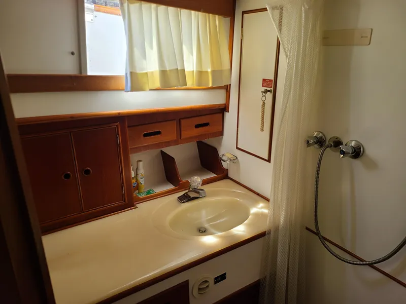 Slide: The Image of 1989 Grand Banks 42 Classic bathroom with sink, wooden cabinets, and shower. - 13
