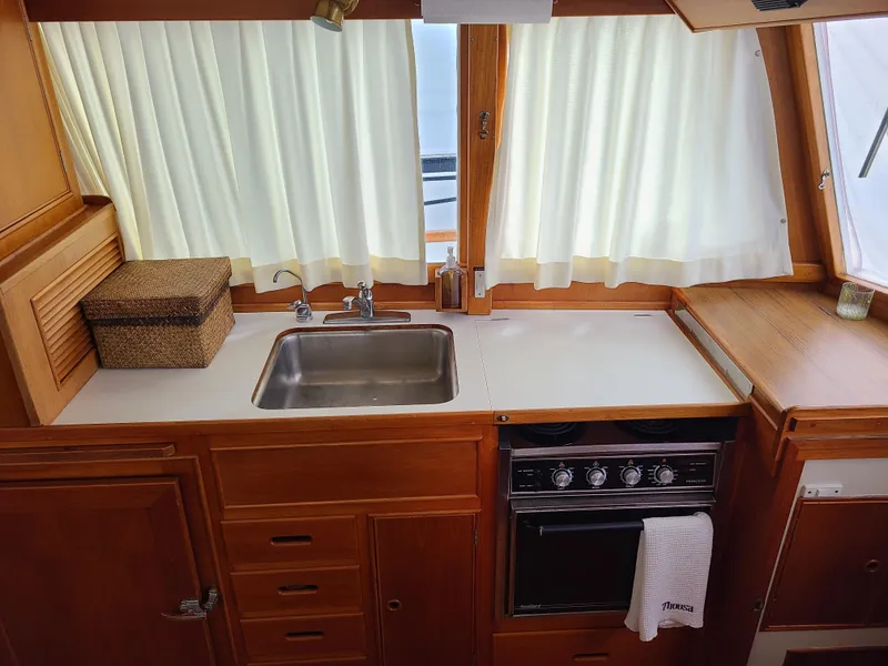 Slide: The Image of 1989 Grand Banks 42 Classic galley with sink, stove, and wooden cabinetry. - 6
