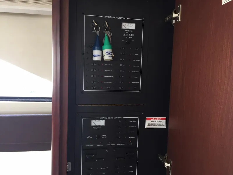 Slide: The Image of Electrical control panel inside 2013 Meridian 341 Sedan yacht with labeled switches and keys. - 27