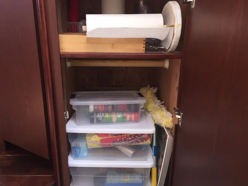Slide: The Image of Cabinet storage with plastic bins, paper towels, and cleaning supplies on a Meridian 341 Sedan, 2013. - 36