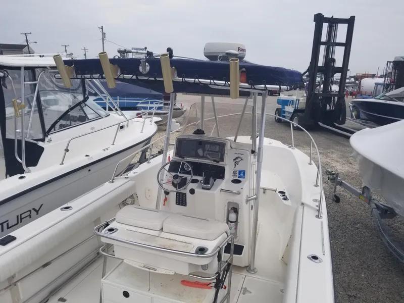 Slide: The Image of 2001 Boston Whaler 23 Outrage boat with center console, docked among other vessels. - 3