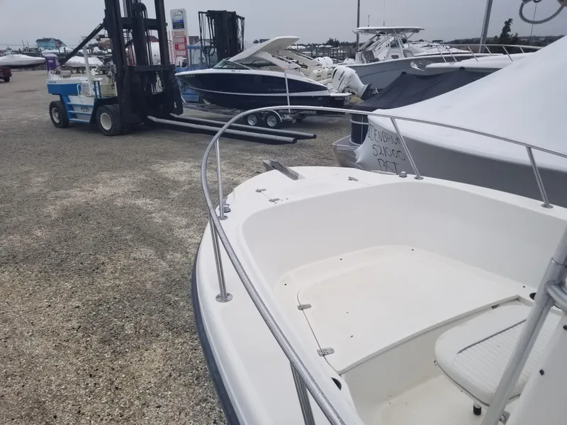 Slide: The Image of 2001 Boston Whaler 23 Outrage boat in a marina with other vessels. - 5