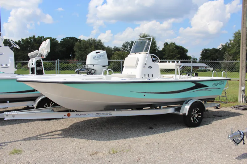 The Image of 2023 Blue Wave 1900 STL boat on a trailer, featuring a sleek design and Suzuki outboard motor. - 1