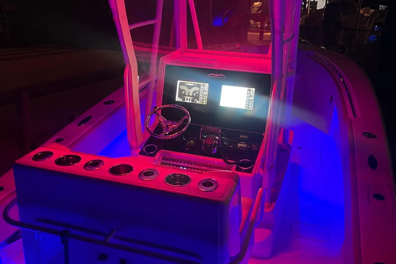 Slide: The Image of Invincible 33 boat cockpit with illuminated controls, vibrant red and blue lighting, 2008 model. - 11