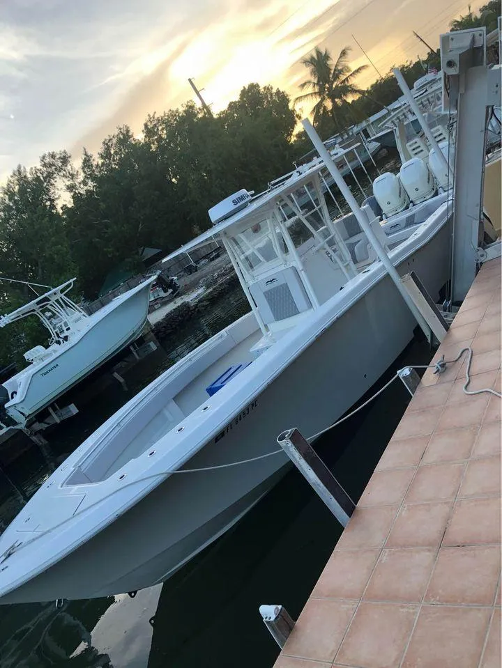 Slide: The Image of 2008 Invincible 33 boat docked at sunset, surrounded by trees and calm water. - 16