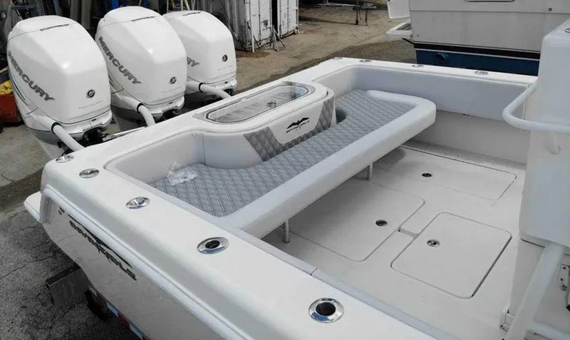 Slide: The Image of 2008 Invincible 33 boat with triple Mercury engines, spacious deck, and seating area. - 2