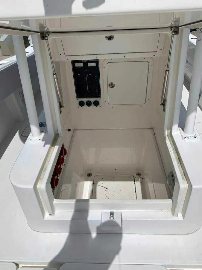 Slide: The Image of Open storage compartment on 2008 Invincible 33 boat, showing interior and control panel. - 4