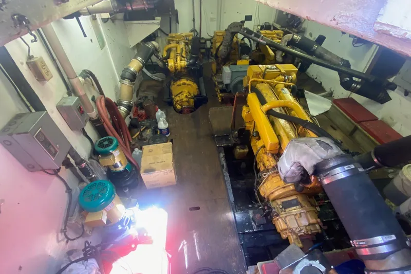 Slide: The Image of Engine room of a 1945 Higgins PT boat with yellow machinery and various equipment. - 16