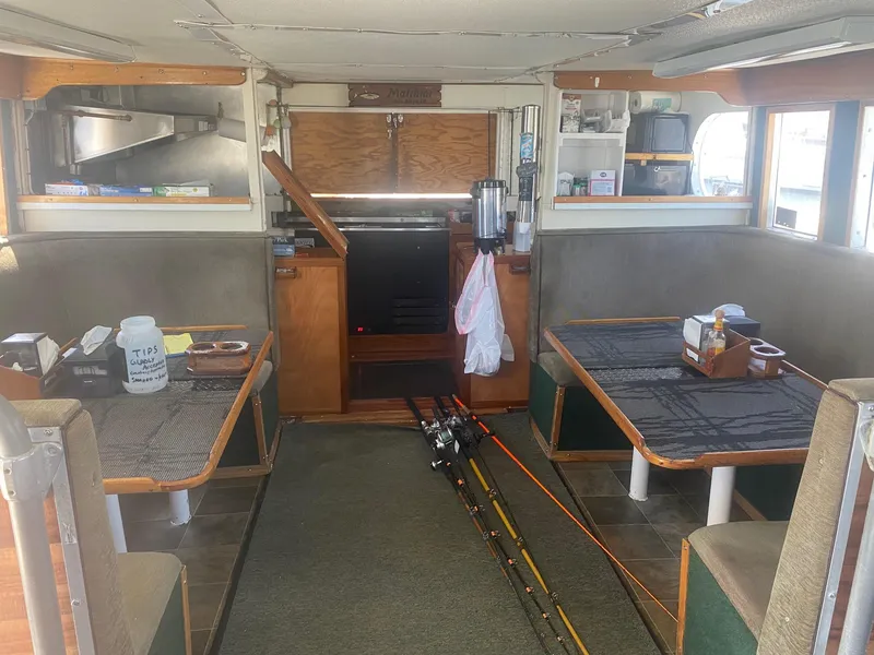 Slide: The Image of Interior of a 1945 Higgins PT boat with fishing rods and seating area. - 9