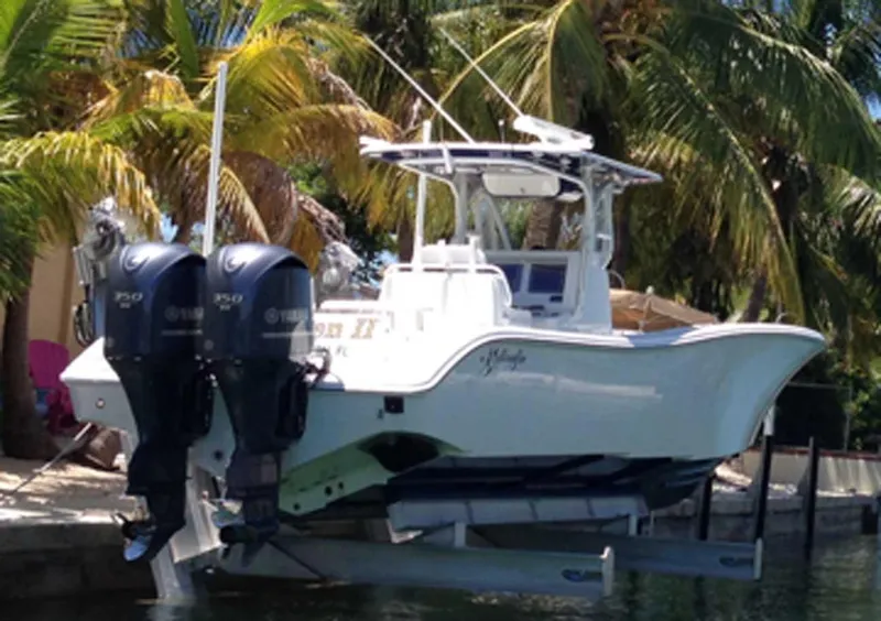 The Image of 2010 Yellowfin Center Console boat with dual engines, docked near palm trees. - 1