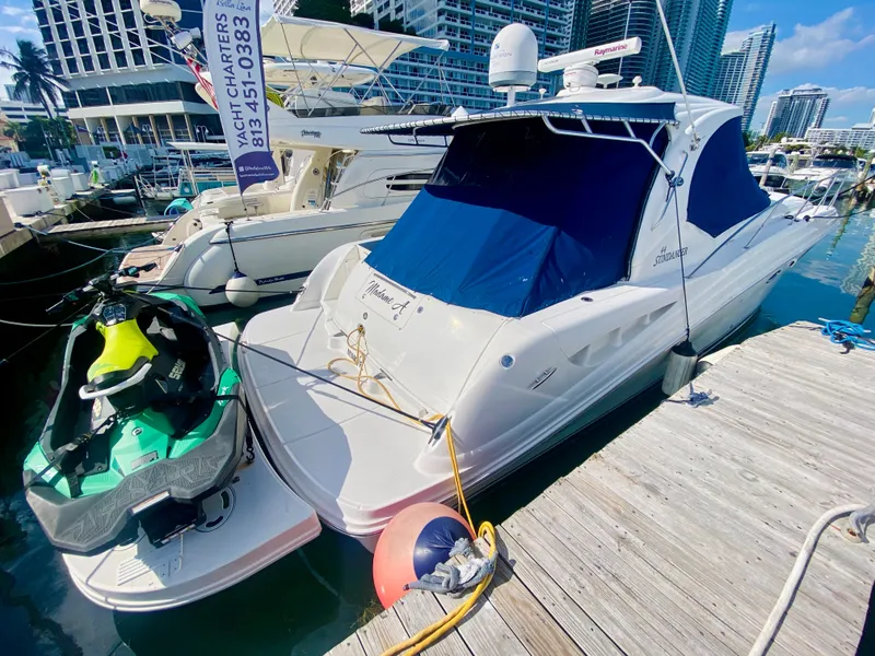 Slide: The Image of 2007 Sea Ray 44 Sundancer yacht docked with jet ski, marina background. - 8