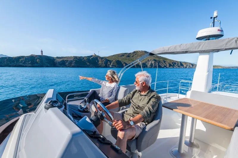 Slide: The Image of Couple enjoying a cruise on a 2025 Beneteau Swift Trawler 41 Fly, scenic coastal view. - 12