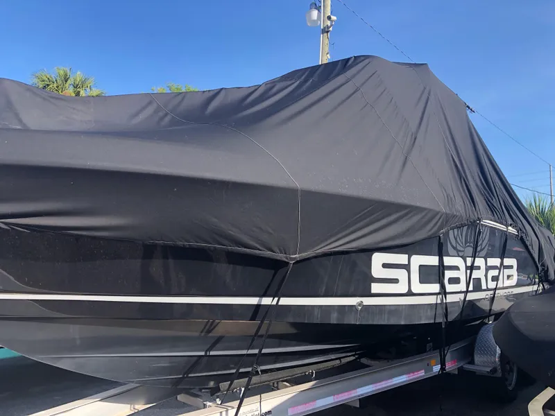 Slide: The Image of 2016 Wellcraft 30 Scarab Offshore Tournament boat covered on a trailer. - 15