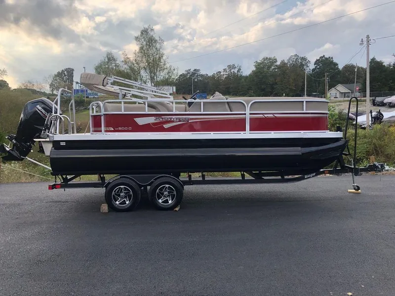 The Image of 2023 Ranger 200C pontoon boat on a trailer, red and black exterior. - 1