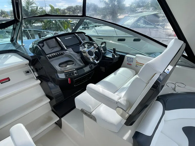 Slide: The Image of 2014 Monterey 320 Sport Yacht helm with modern controls and white seating. - 25