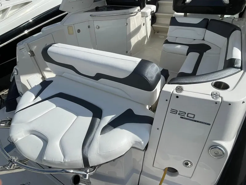 Slide: The Image of 2014 Monterey 320 Sport Yacht interior seating area with white and black upholstery. - 27