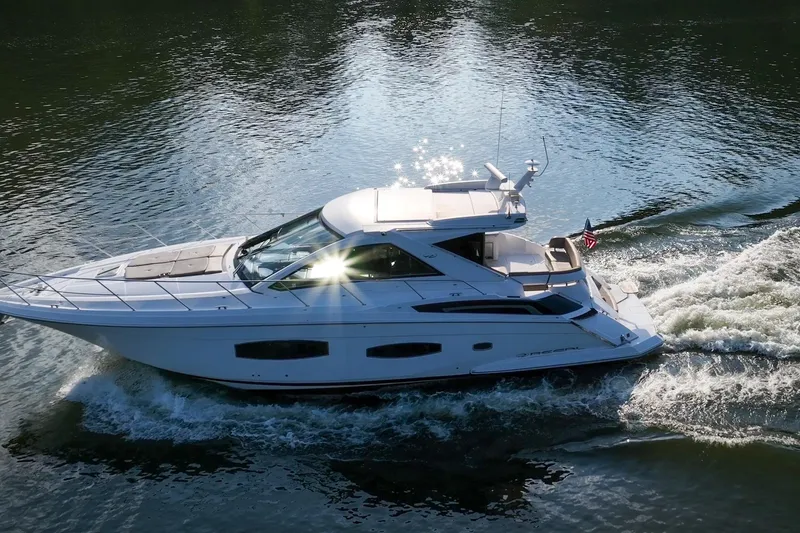 Slide: The Image of 2015 Regal 53 Sport Coupe cruising on a sunlit waterway. - 11
