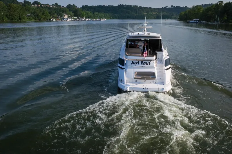 Slide: The Image of 2015 Regal 53 Sport Coupe cruising on a scenic river, rear view. - 15
