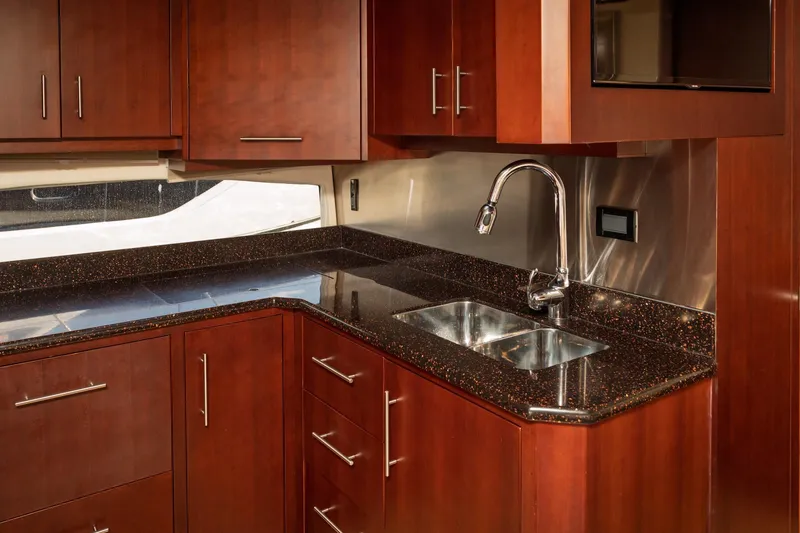 Slide: The Image of Luxurious kitchen interior of 2015 Regal 53 Sport Coupe with sleek wood cabinetry. - 31