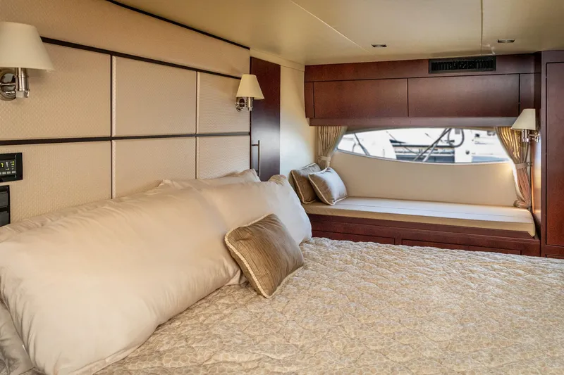 Slide: The Image of Luxurious interior of 2015 Regal 53 Sport Coupe yacht with elegant bedding and window seating. - 34