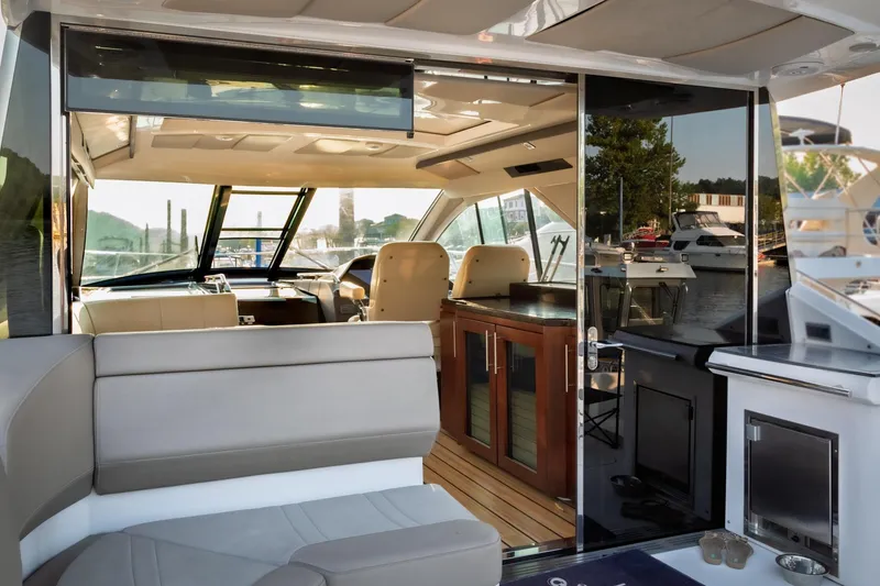 Slide: The Image of Interior of 2015 Regal 53 Sport Coupe yacht, featuring luxurious seating and modern design. - 52