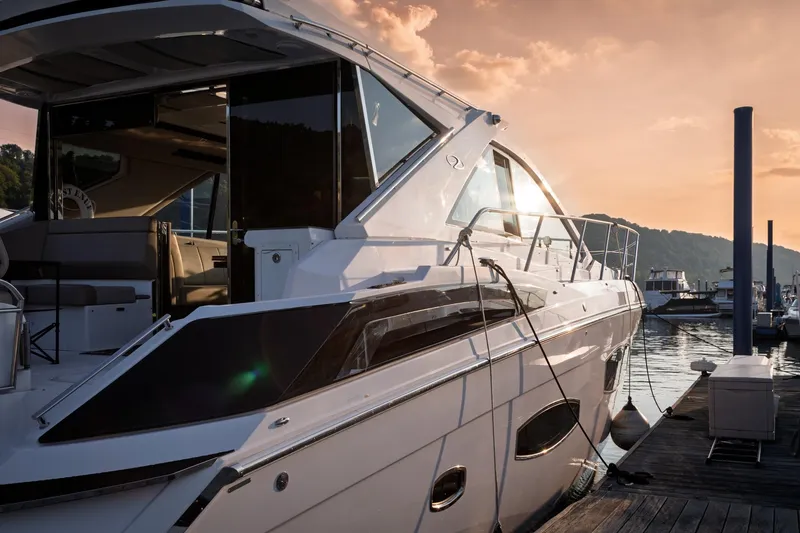 Slide: The Image of 2015 Regal 53 Sport Coupe yacht docked at sunset, showcasing sleek design and luxury. - 60