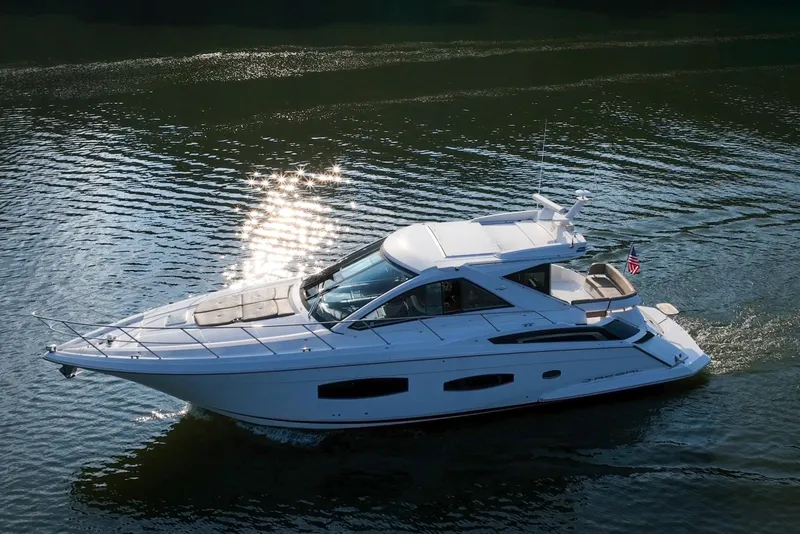 Slide: The Image of 2015 Regal 53 Sport Coupe yacht cruising on a sunlit water surface. - 9