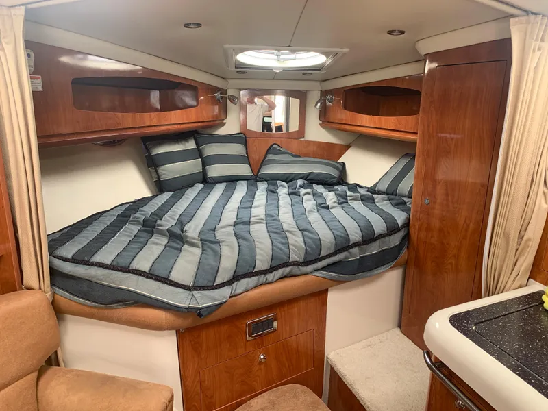 Slide: The Image of 2007 Four Winns 318 Vista cabin interior with bed and wooden cabinetry. - 14