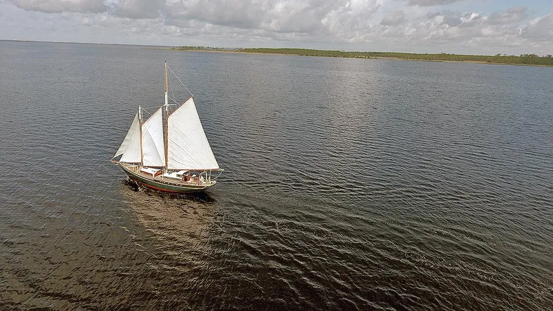 Slide: The Image of 1979 Custom Van Dyne Schooner sailing on open water under cloudy skies. - 2