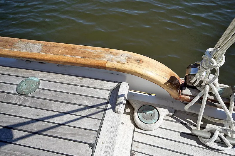 Slide: The Image of Close-up of 1979 Custom Van Dyne Schooner deck with wooden rail and nautical ropes. - 23