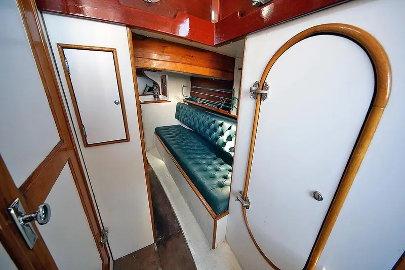 Slide: The Image of 1979 Custom Van Dyne Schooner interior with green cushioned seating and wooden accents. - 30