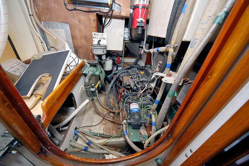 Slide: The Image of Engine room of a 1979 Custom Van Dyne Schooner with visible machinery and hoses. - 33