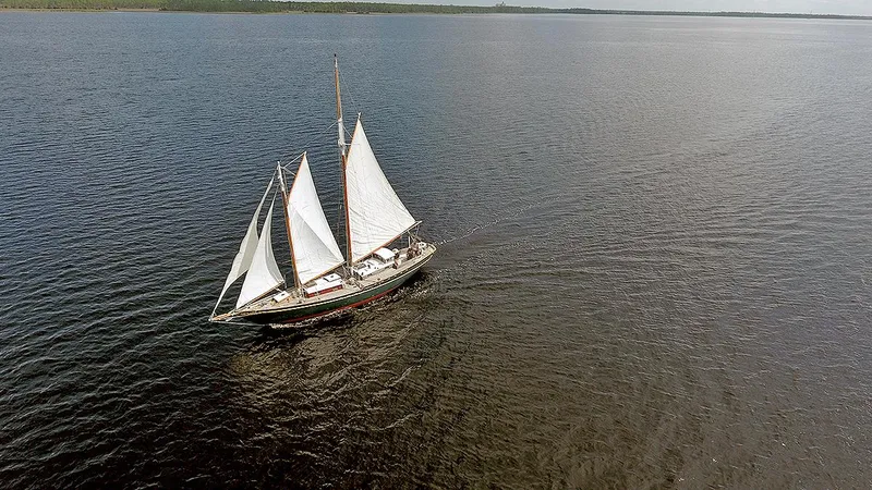 Slide: The Image of Aerial view of a 1979 Custom Van Dyne Schooner sailing on open water. - 4