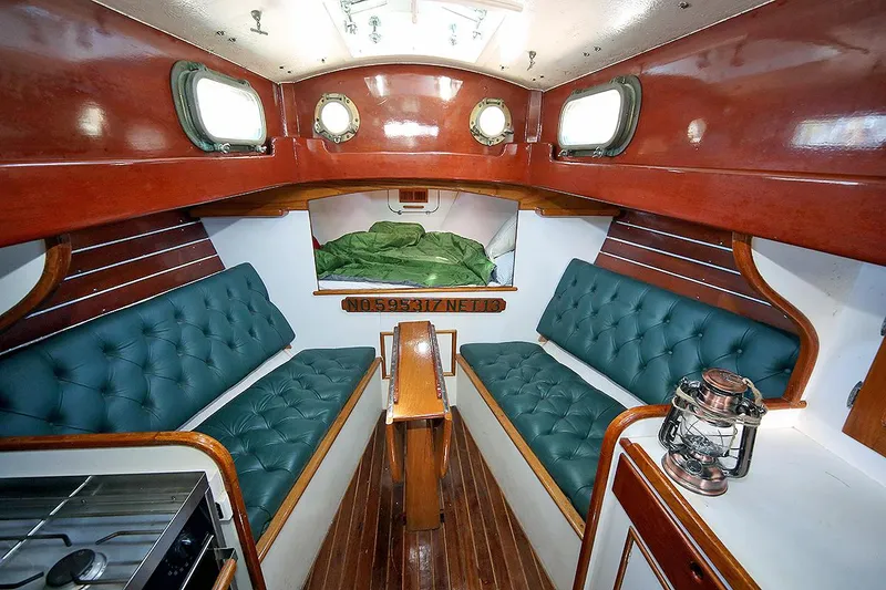 Slide: The Image of Interior of a 1979 Custom Van Dyne Schooner with green cushioned seating and wooden finishes. - 41