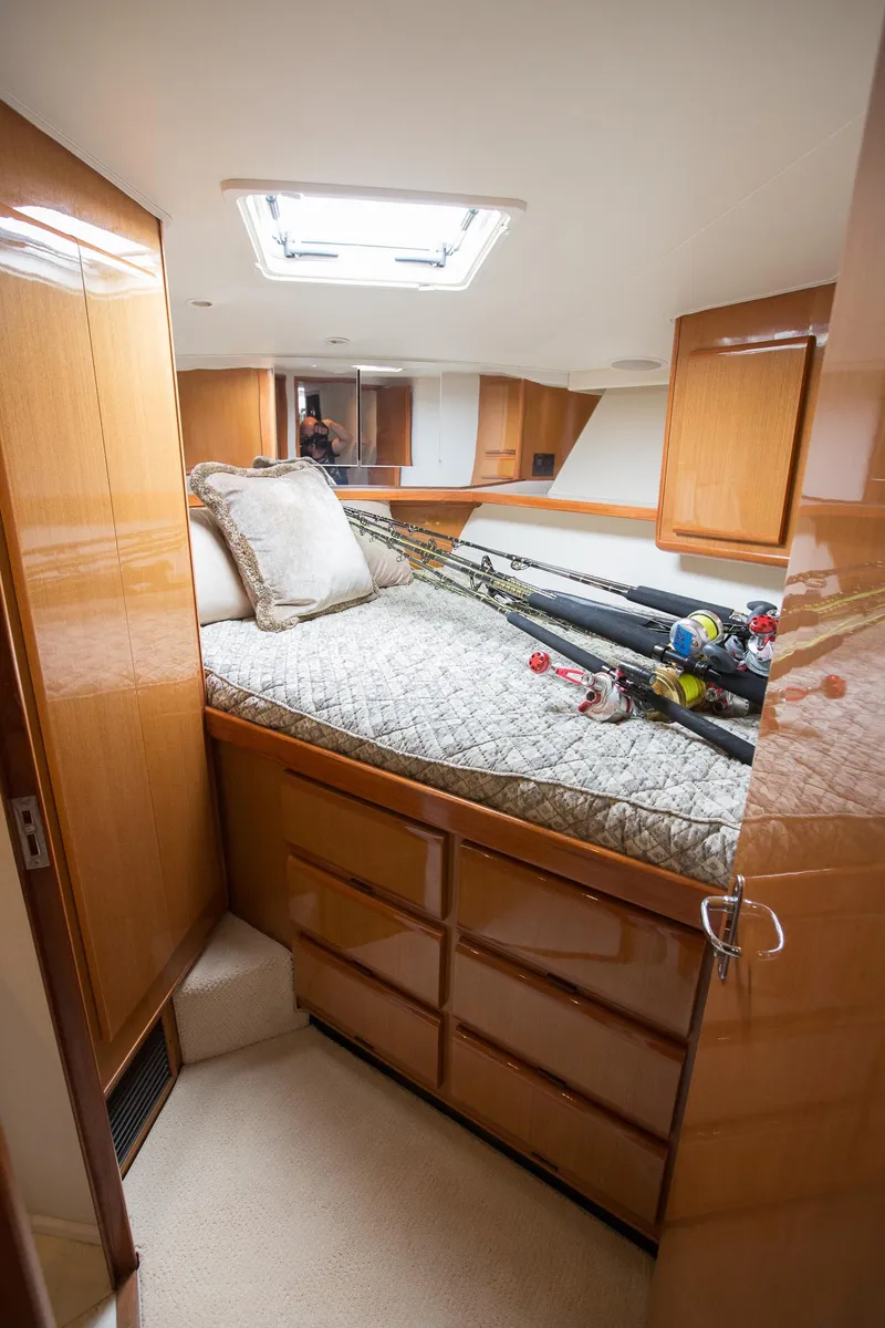Slide: The Image of Cozy cabin interior of 2000 Viking 50 Convertible Sport Fisher with fishing rods. - 29