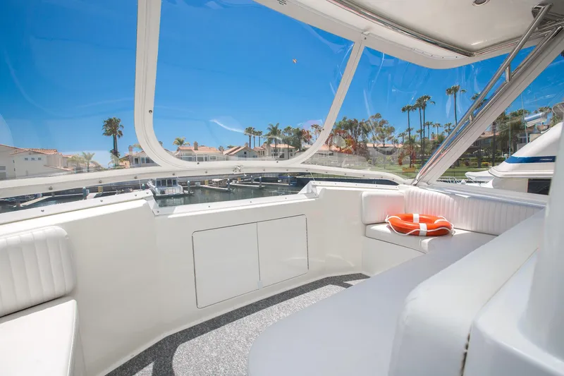 Slide: The Image of Viking 50 Convertible Sport Fisher 2000 interior with seating, clear windows, and sunny marina view. - 37