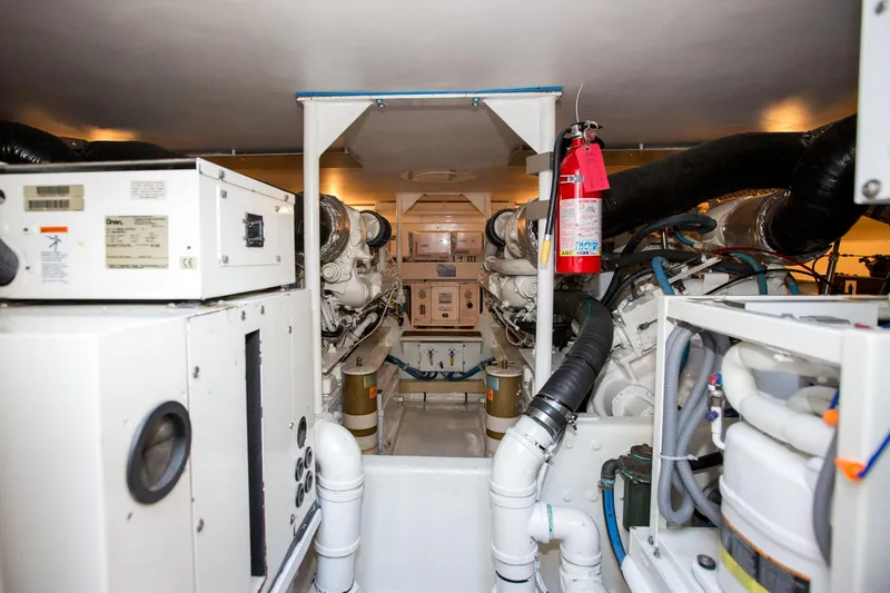Slide: The Image of Engine room of 2000 Viking 50 Convertible Sport Fisher with machinery and fire extinguisher. - 49