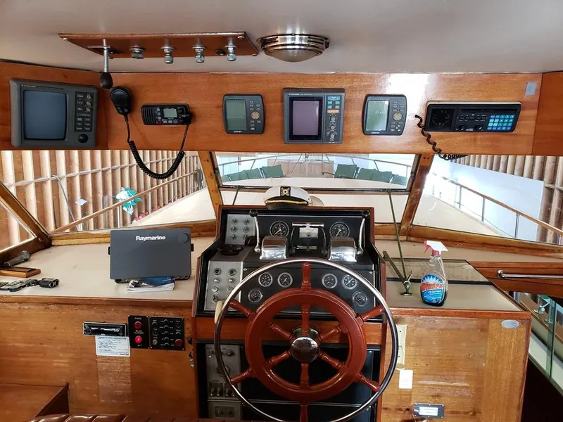 Slide: The Image of 1964 Chris-Craft Constellation helm with vintage wooden steering wheel and modern navigation equipment. - 21