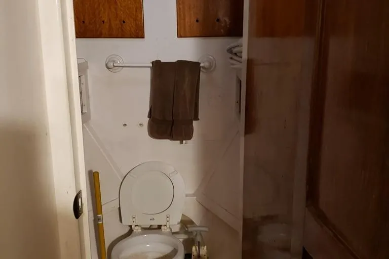 Slide: The Image of 1964 Chris-Craft Constellation bathroom with toilet, towel rack, and wooden cabinets. - 47