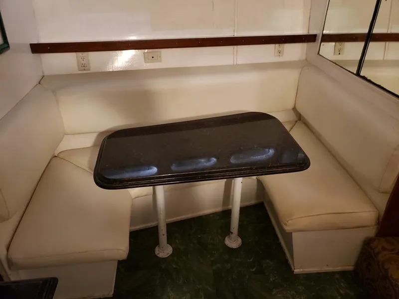 Slide: The Image of 1964 Chris-Craft Constellation interior with white seating and a dark table. - 32