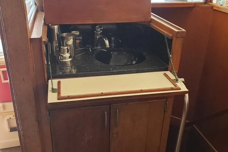 Slide: The Image of 1964 Chris-Craft Constellation boat interior with wooden cabinetry and sink. - 49