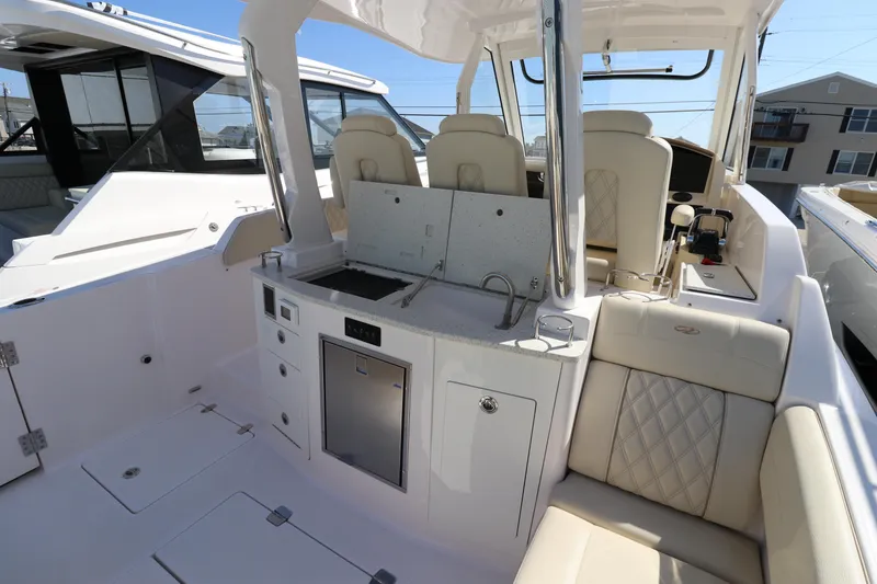 Slide: The Image of 2019 Regal 33 SAV boat interior with seating and kitchenette area. - 12
