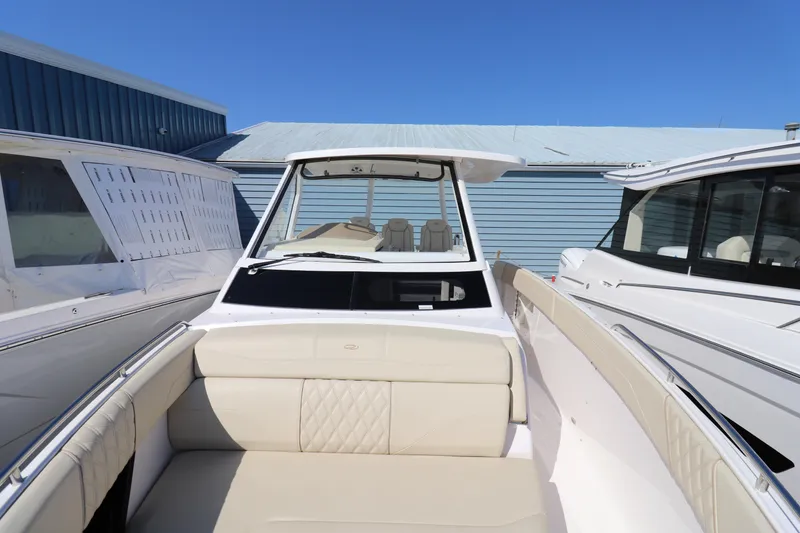 Slide: The Image of 2019 Regal 33 SAV boat with beige seating, docked between two other boats. - 17