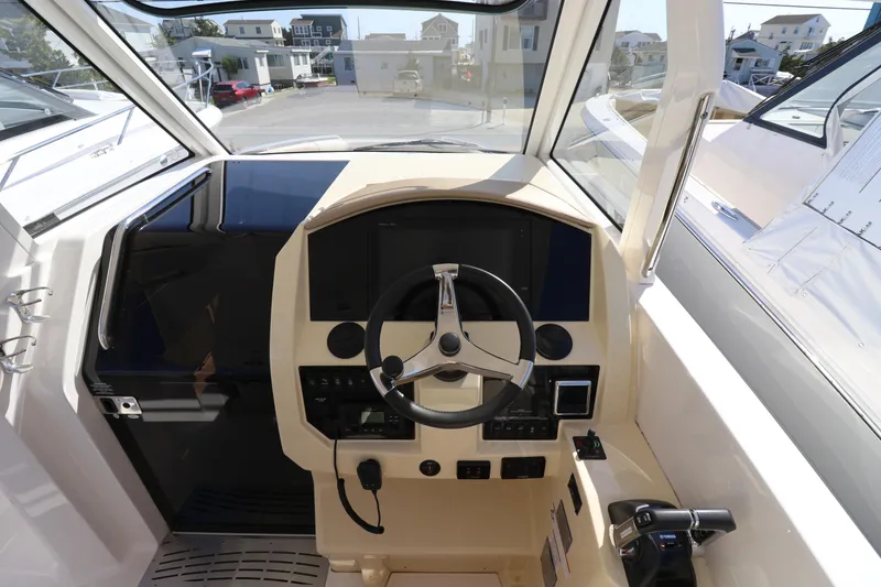 Slide: The Image of Cockpit of 2019 Regal 33 SAV boat with steering wheel and control panel. - 19